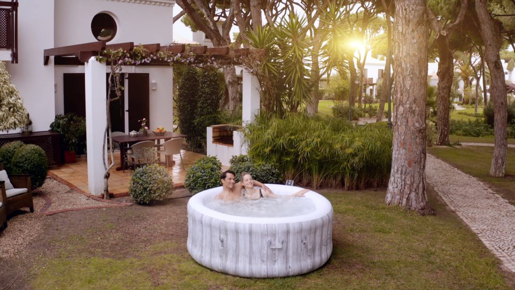 Opuštanje u kućnom Lay-Z Spa masažnom bazenu za dvoje na zalasku sunca.